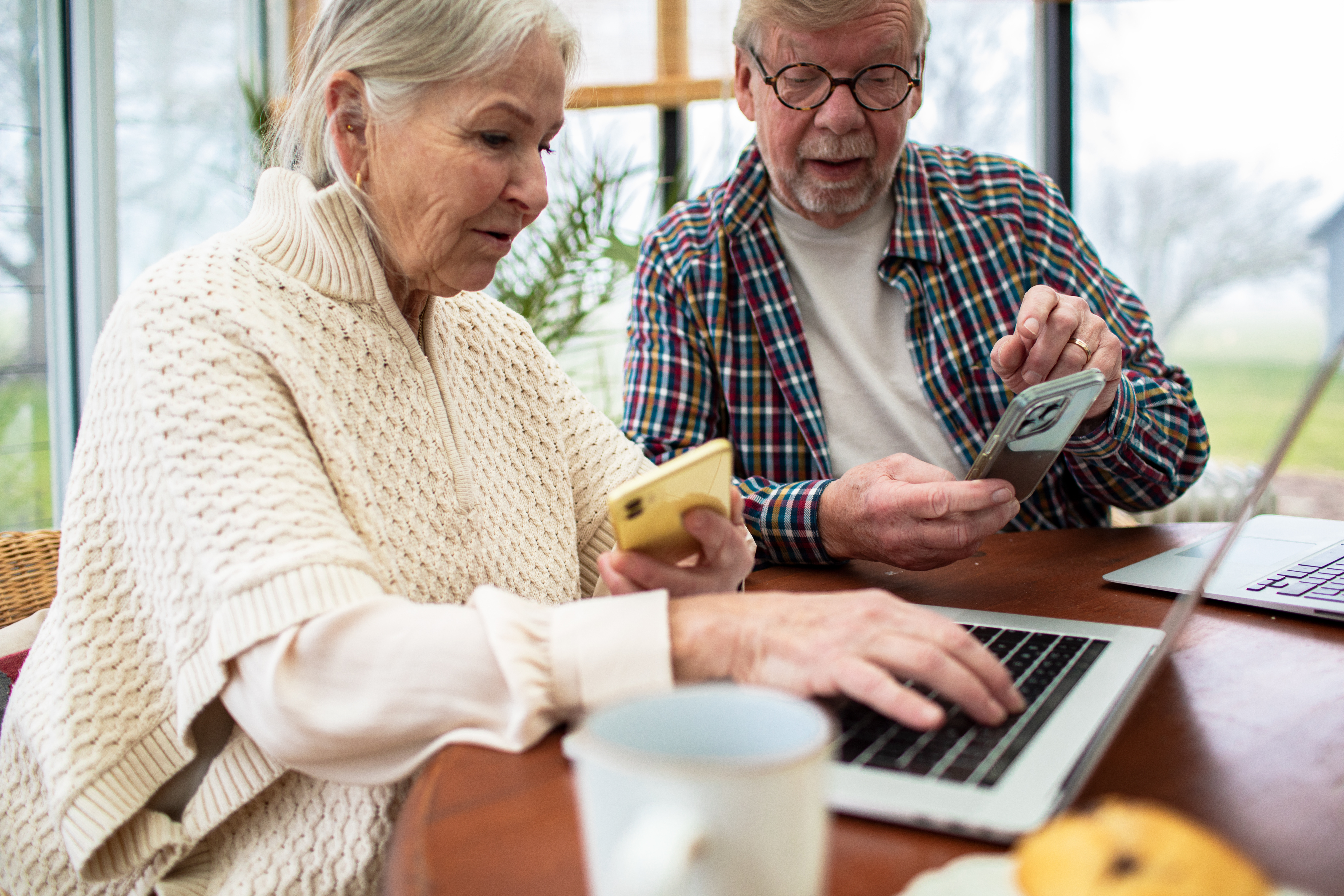 Stel leert werken met smartphone en laptop