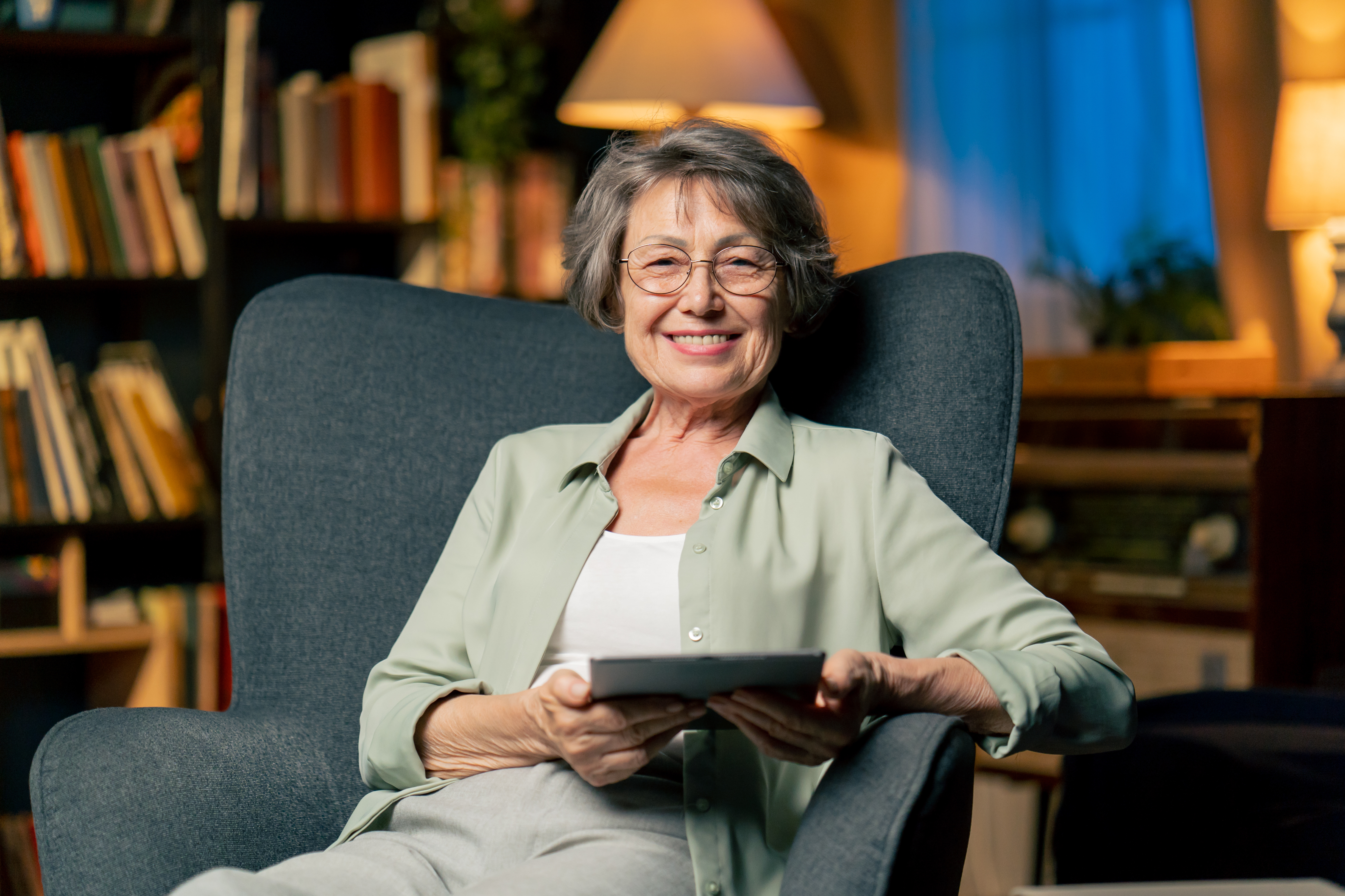 Oudere vrouw werkt comfortabel met tablet thuis